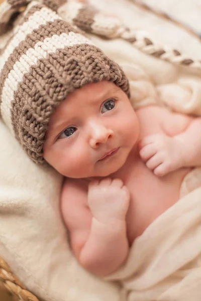 Bebé recién nacido en un sombrero de punto en una canasta de mimbre. Maternidad . — Foto de Stock