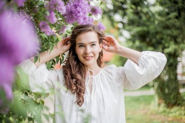 Çiçek açan leylakların yanında genç ve güzel bir kadının portresi. Bahar.