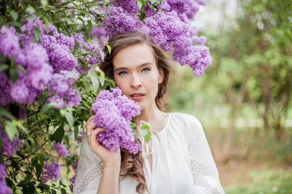 Портрет красивої молодої жінки біля квітучого бузку. Весна . — стокове фото