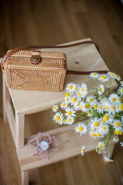 Küçük dokuma kadın çantası, bir buket papatyalar. Bahar. Rahat.