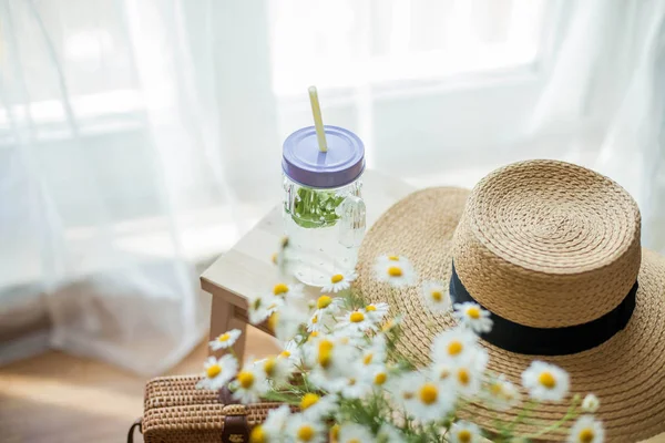 Borsa da donna in vimini, bouquet di margherite, limonata con menta, cappello in vimini, sedia in legno. Primavera. Accogliente . — Foto Stock