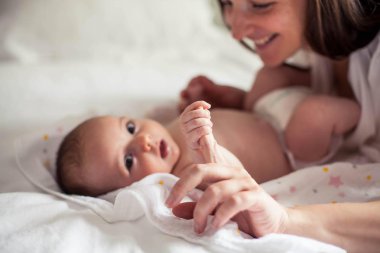 Genç ve güzel bir anne bir bebek doğuruyor. Annem bebeğini öper. Çocuk yatak odası.