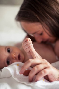 Genç ve güzel bir anne bir bebek doğuruyor. Annem bebeğini öper. Çocuk yatak odası.