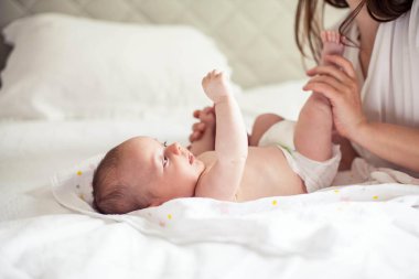 Genç ve güzel bir anne bir bebek doğuruyor. Annem bebeğini öper. Çocuk yatak odası.