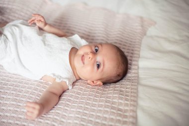 Küçük sevimli kız 3 aylık yatakta yatıyor. Bebek. Çocuk yatak odası.