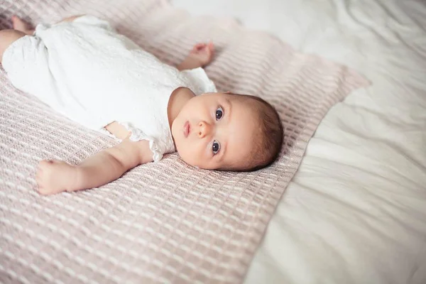 Little cute girl 3 months old is lying on the bed. Baby. Children bedroom. — Stock Photo, Image