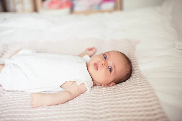 Klein schattig meisje 3 maanden oud is liggend op het bed. Baby. Kinderen slaapkamer. — Stockfoto