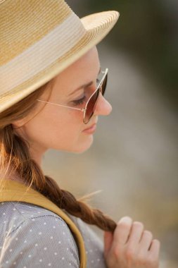 Close. Sırt çantası olan şapkalı güzel kızıl saçlı genç bir kadın. Turizm.