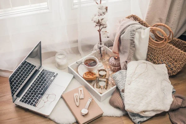 Tonlu fotoğraf. Sonbahar dekoru. Bir laptop, bir kupa sıcak çay, bir çörek, mumlar. Samimi. Sonbahar.