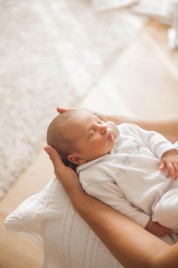 Yeni doğmuş şirin bebek annesinin kollarında uyuyor. Annelik.