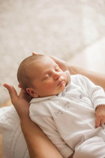 Söta nyfödda barn sover i mammas armar. Moderskap. — Stockfoto