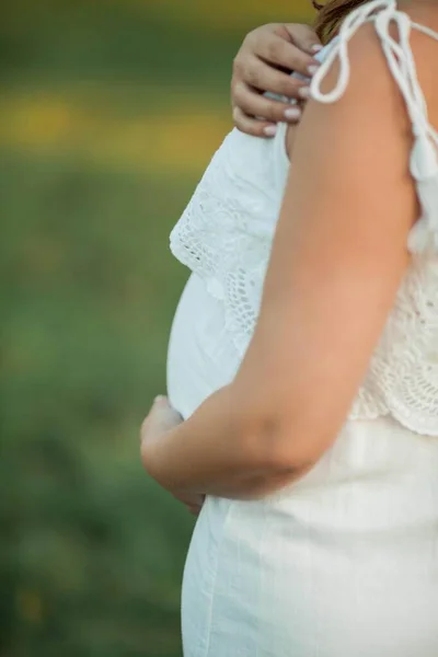 Närbild. Porträtt av en gravid kvinna i solen. Ung vacker gravid kvinna med en krans på huvudet på fältet. Moderskap. Varm höst. — Stockfoto