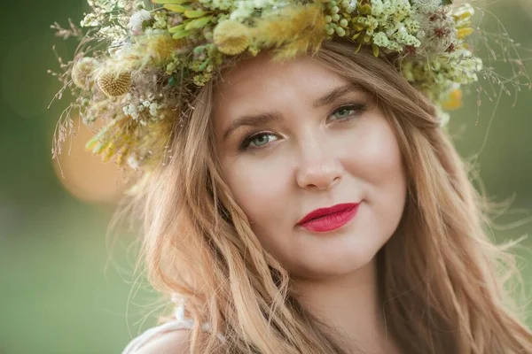 Close-up. Retrato de uma mulher grávida ao sol. Jovem mulher grávida bonita com uma coroa de flores na cabeça no campo. Maternidade. Outono quente . — Fotografia de Stock