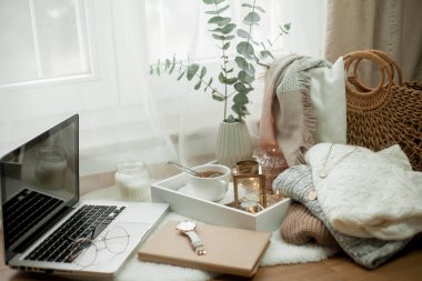 Tonlu fotoğraf. Sonbahar dekoru. Bir laptop, bir kupa sıcak çay, bir çörek, mumlar. Samimi. Sonbahar.