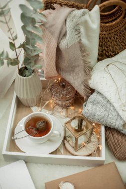 Tonlu fotoğraf. Sonbahar dekoru. Bir laptop, bir kupa sıcak çay, bir çörek, mumlar. Samimi. Sonbahar.