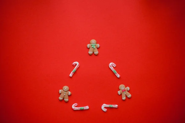Рождественские конфеты на красном фоне. Пряничные человечки . — стоковое фото