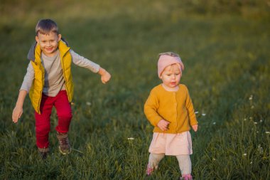 Küçük tatlı bir oğlan ve kız sonbahar bahçesinde oynuyorlar. Kırmızı elmalı kız ve erkek kardeşler. Sıcak ve aydınlık sonbahar.