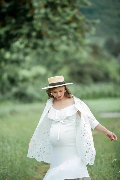 若い美しい妊婦の肖像画 公園を散歩する藁帽子の妊婦 — ストック写真