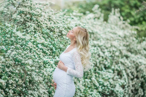 Mladá Krásná Těhotná Žena Krajkové Bílé Šaty Procházky Kvetoucím Parku — Stock fotografie