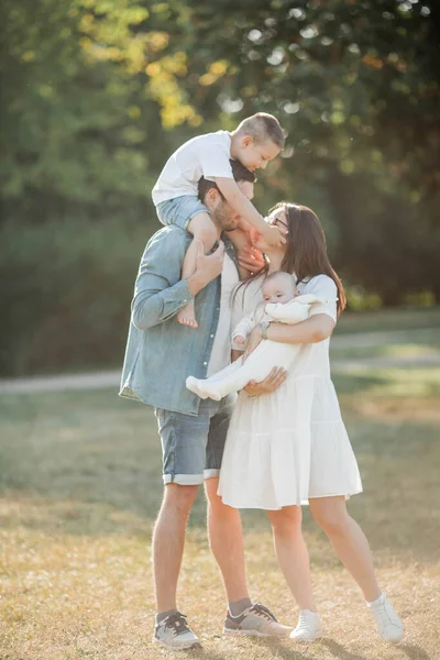 Genç Güzel Bir Aile Parkta Yürüyor Gün Batımında Aile Portresi — Stok fotoğraf