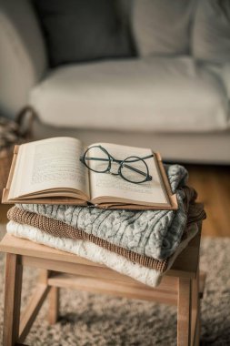 Tonlu fotoğraf. Sonbahar dekoru. Örgü süveter, kitap, gözlük. Samimi. Sonbahar. Sonbahar havası.