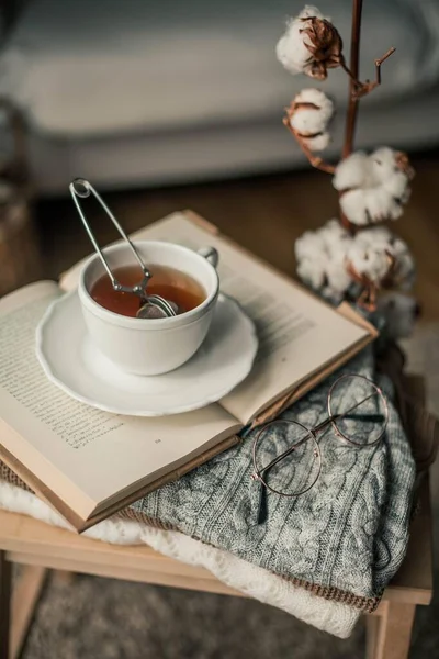 Tonlu fotoğraf. Sonbahar dekoru. Bir kupa sıcak çay, örgü süveter, kitap, bardak. Samimi. Sonbahar. Sonbahar havası.