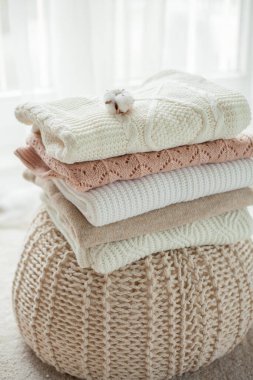 Bir yığın örgü kazak, pamuk. Kadın kazakları kanepenin üzerinde yatıyor. Sıcak sonbahar kıyafetleri. Düş.