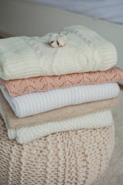 Bir yığın örgü kazak, pamuk. Kadın kazakları kanepenin üzerinde yatıyor. Sıcak sonbahar kıyafetleri. Düş.