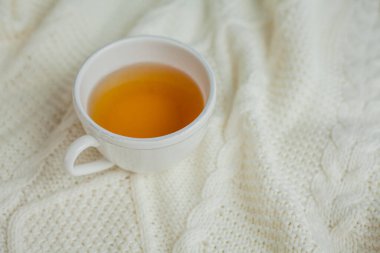 Örgü örülmüş bir fincan sıcak çay. Sıcak sonbahar.