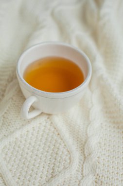 Örgü örülmüş bir fincan sıcak çay. Sıcak sonbahar.