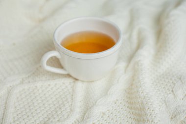 Örgü örülmüş bir fincan sıcak çay. Sıcak sonbahar.