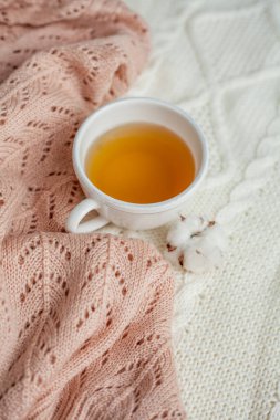 Bir kupa sıcak çay, pamuk örülmüş battaniye üzerine örülmüş süveter. Sıcak sonbahar.