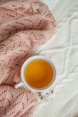 Bir kupa sıcak çay, pamuk örülmüş battaniye üzerine örülmüş süveter. Sıcak sonbahar.