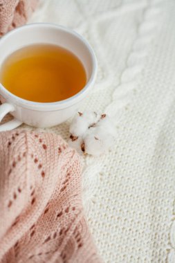 Bir kupa sıcak çay, pamuk örülmüş battaniye üzerine örülmüş süveter. Sıcak sonbahar.