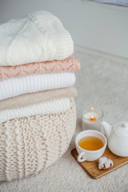 Bir yığın örgü süveter, bir kupa sıcak çay, bir çaydanlık, bir sedirin üzerinde ahşap bir tezgah. Sıcak bir sonbahar. Kış kahvaltısı. Güller. Mum..