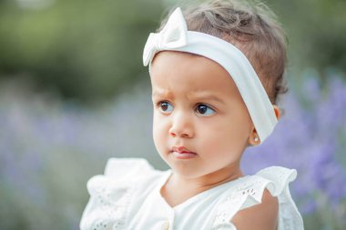 Güzel genç anne ve küçük kızı çiçek açan lavantada. Uluslararası aile. Gün batımında güzel küçük bir kızın portresi..