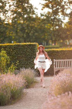 Gün batımında güzel genç bir kadın. Lavanta çiçekli güzel bir kadının portresi..