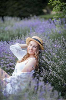Gün batımında güzel genç bir kadın. Lavanta çiçekli güzel bir kadının portresi..