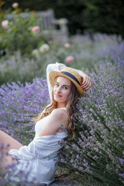 Gün batımında güzel genç bir kadın. Lavanta çiçekli güzel bir kadının portresi..