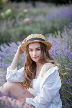 Gün batımında güzel genç bir kadın. Lavanta çiçekli güzel bir kadının portresi..