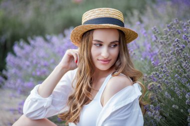 Gün batımında güzel genç bir kadın. Lavanta çiçekli güzel bir kadının portresi..