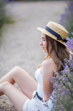 Gün batımında güzel genç bir kadın. Lavanta çiçekli güzel bir kadının portresi..