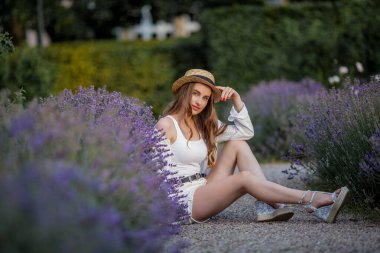Gün batımında güzel genç bir kadın. Lavanta çiçekli güzel bir kadının portresi..