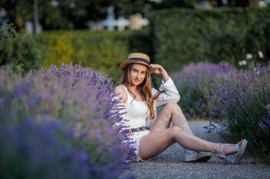 Gün batımında güzel genç bir kadın. Lavanta çiçekli güzel bir kadının portresi..