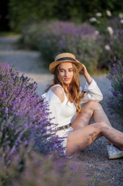 Gün batımında güzel genç bir kadın. Lavanta çiçekli güzel bir kadının portresi..