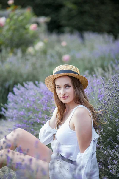 Gün batımında güzel genç bir kadın. Lavanta çiçekli güzel bir kadının portresi..
