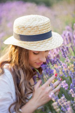 Gün batımında güzel genç bir kadın. Lavanta çiçekli güzel bir kadının portresi..