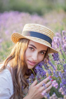 Gün batımında güzel genç bir kadın. Lavanta çiçekli güzel bir kadının portresi..