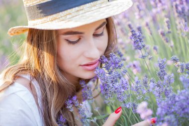 Gün batımında güzel genç bir kadın. Lavanta çiçekli güzel bir kadının portresi..