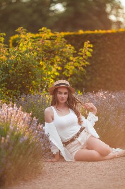 Gün batımında güzel genç bir kadın. Lavanta çiçekli güzel bir kadının portresi..